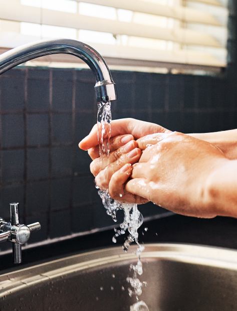 Someone washing their hands under running water